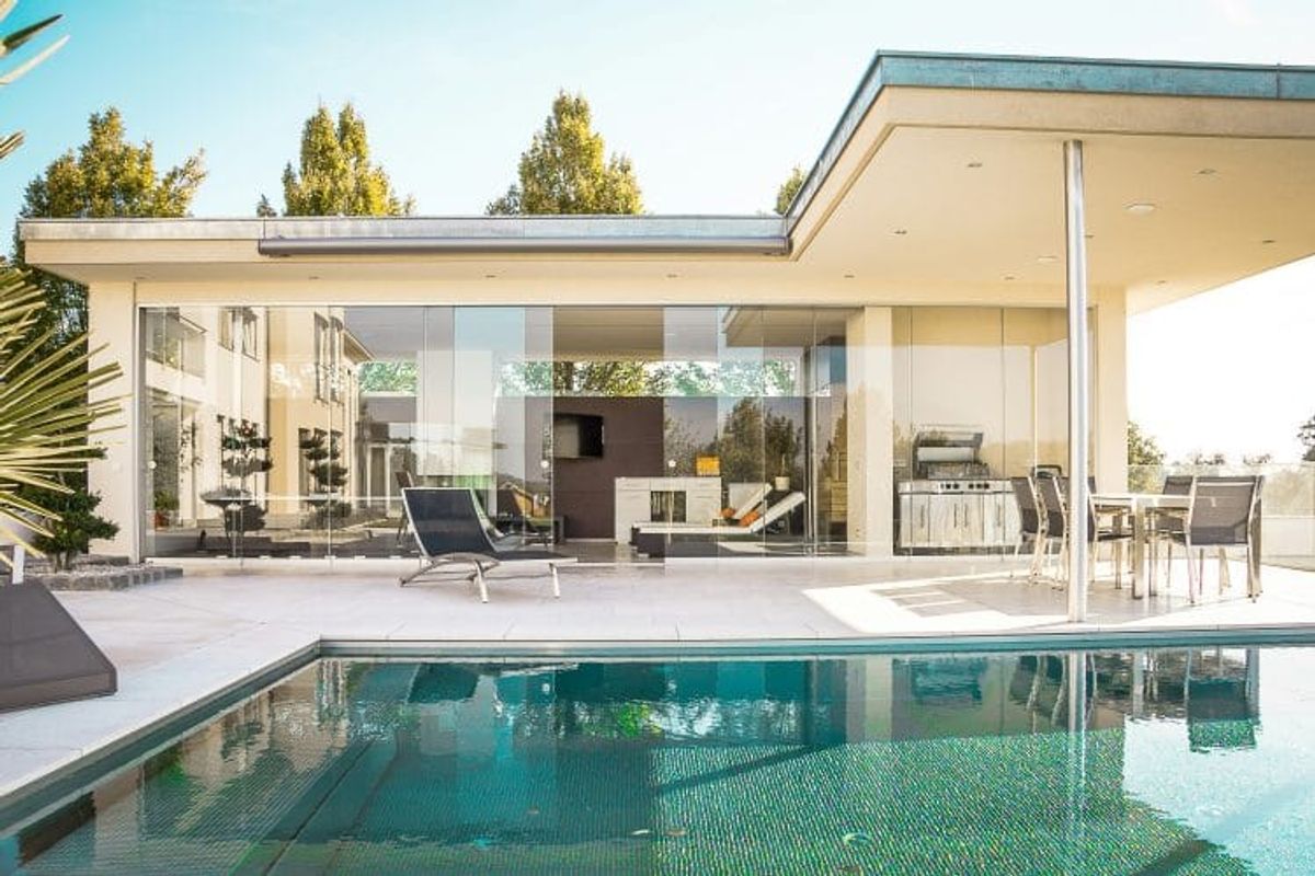 Modern house with pool and outdoor seating area.