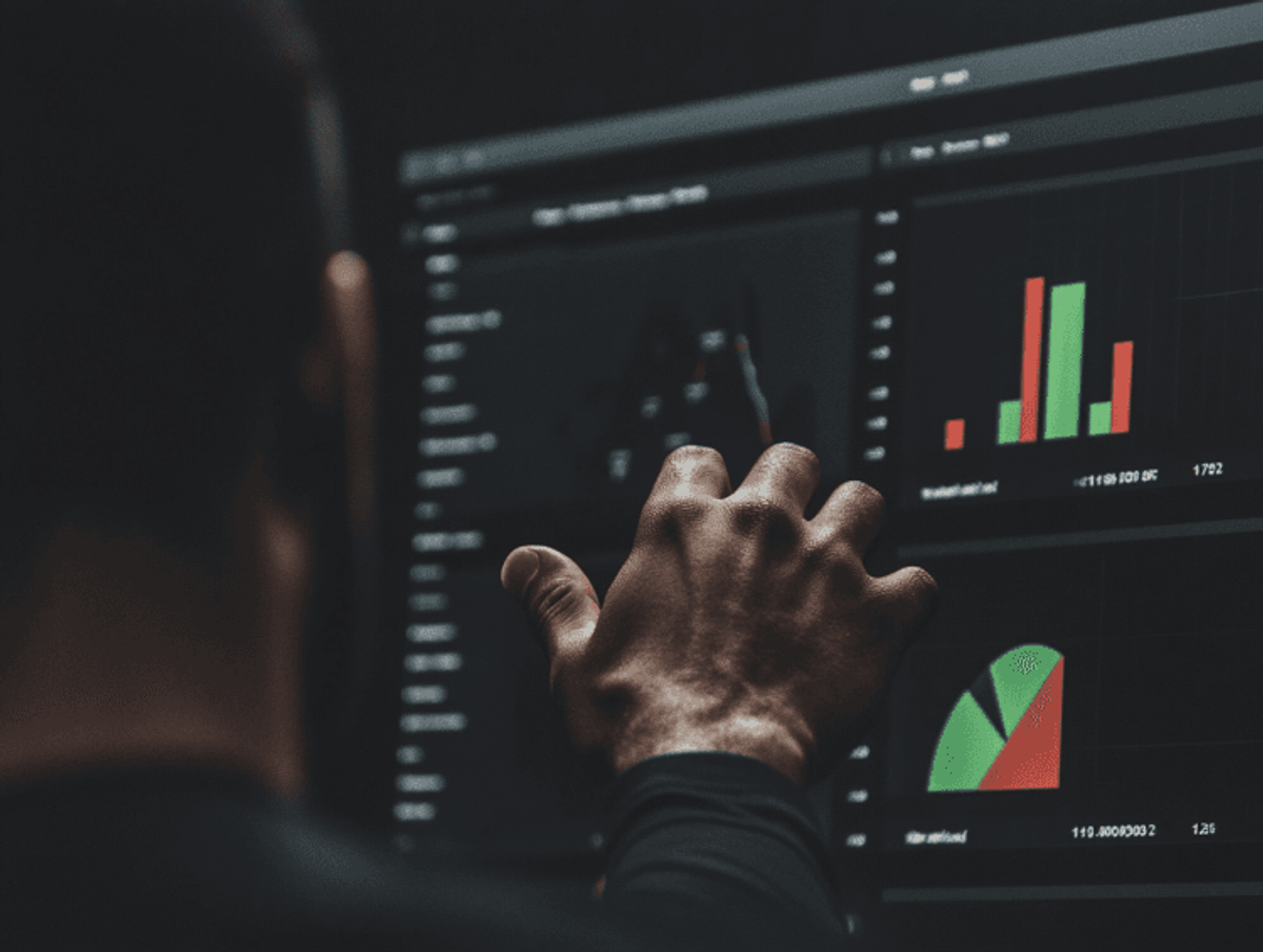 Person analyzing financial graphs on a touchscreen.