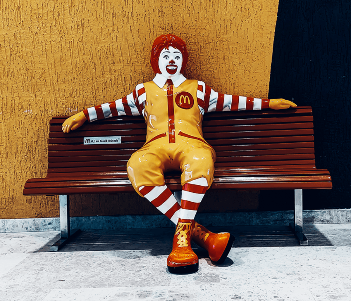 Ronald McDonald statue sitting on a bench