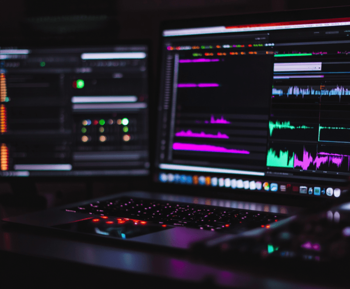 Audio editing software displayed on computer screens.