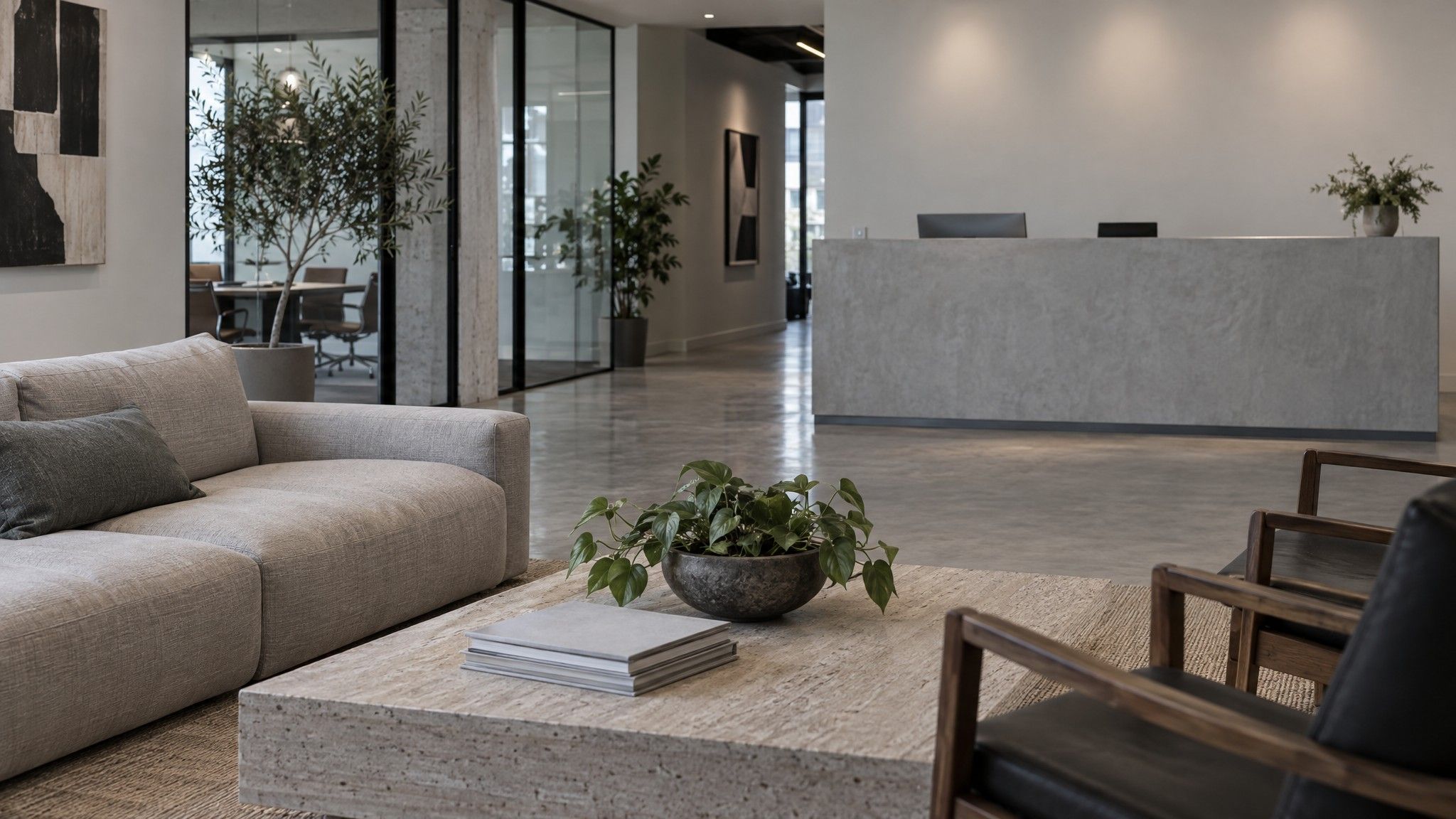 Agency reception with a low sofa and magazines face down on a table