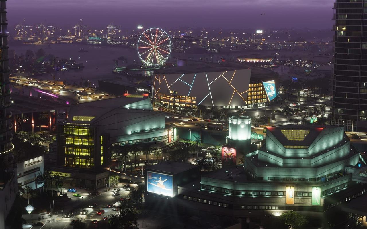 Night-time aerial view of the Vice City arena, concert hall and arts centre district with a lit Ferris wheel on the waterfront — official Grand Theft Auto VI screenshot