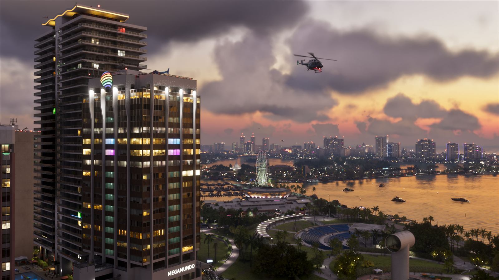 Downtown Vice City at dusk, with a high-rise tower, a waterfront park, a Ferris wheel and a helicopter over the bay — official Grand Theft Auto VI screenshot