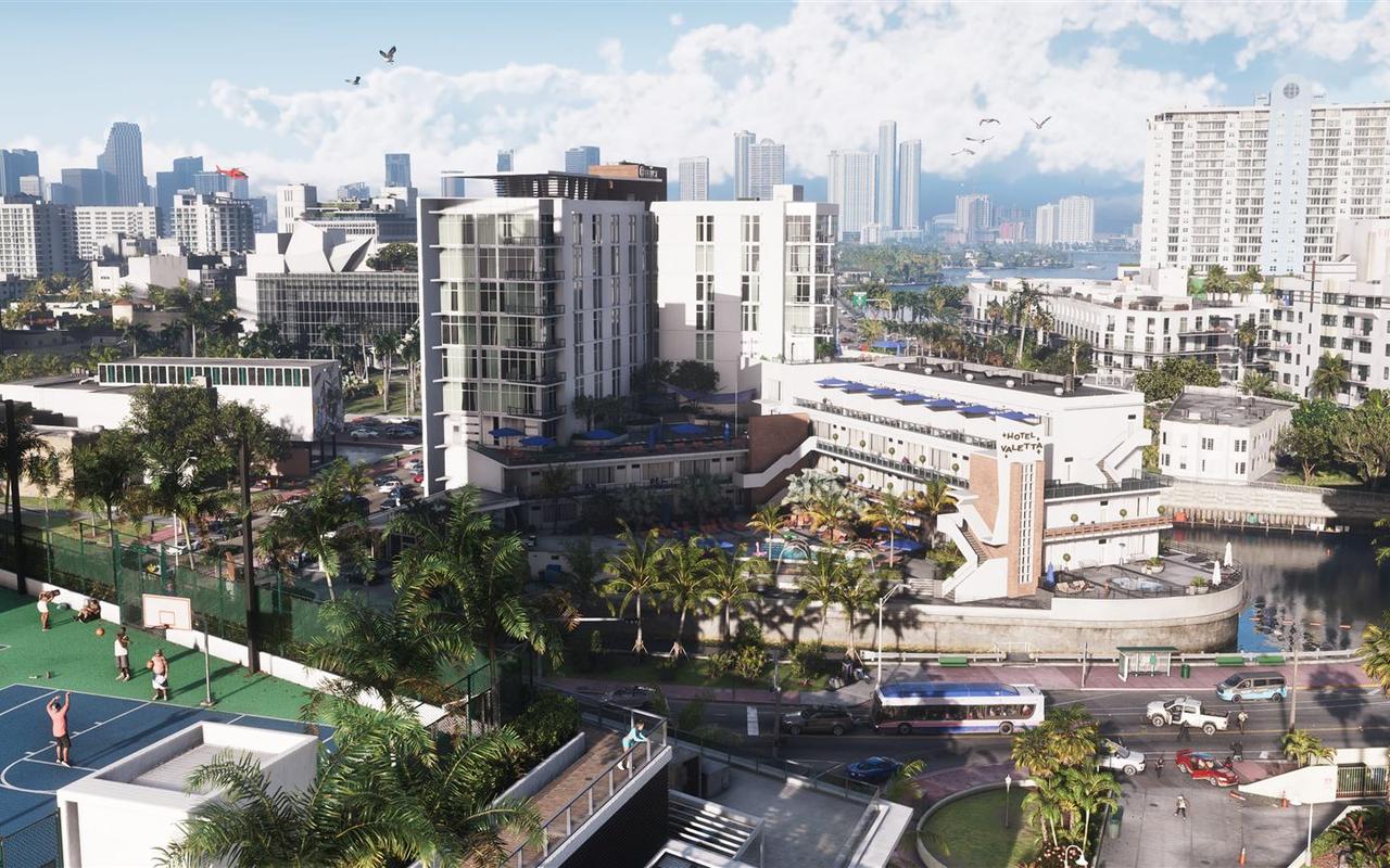 Daytime view across Vice City rooftops toward the downtown skyline, with a hotel pool and a basketball court in the foreground — official Grand Theft Auto VI screenshot