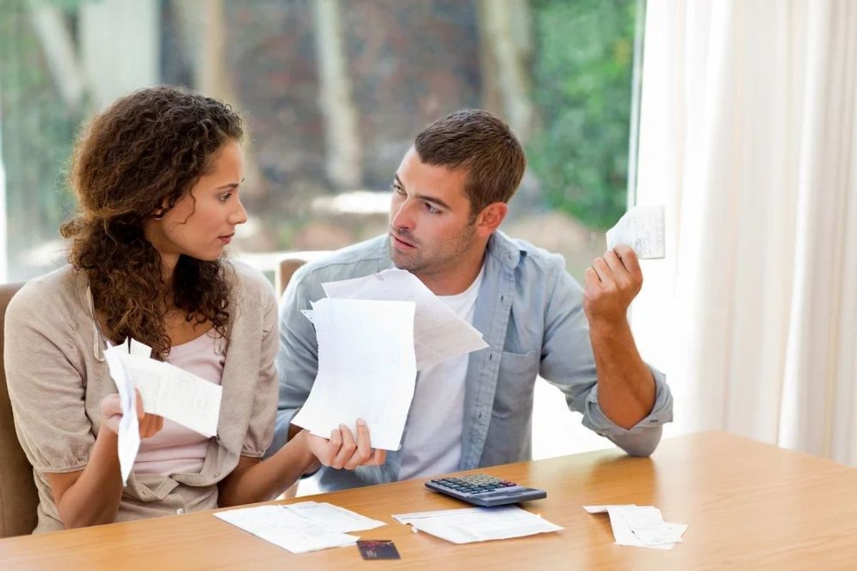 A couple sitting at a table, frustrated with their budget