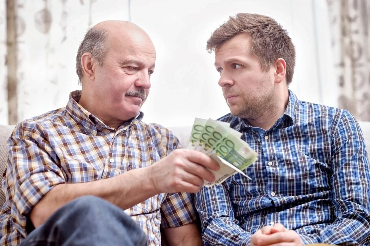 Grandpa handing money to adult kid