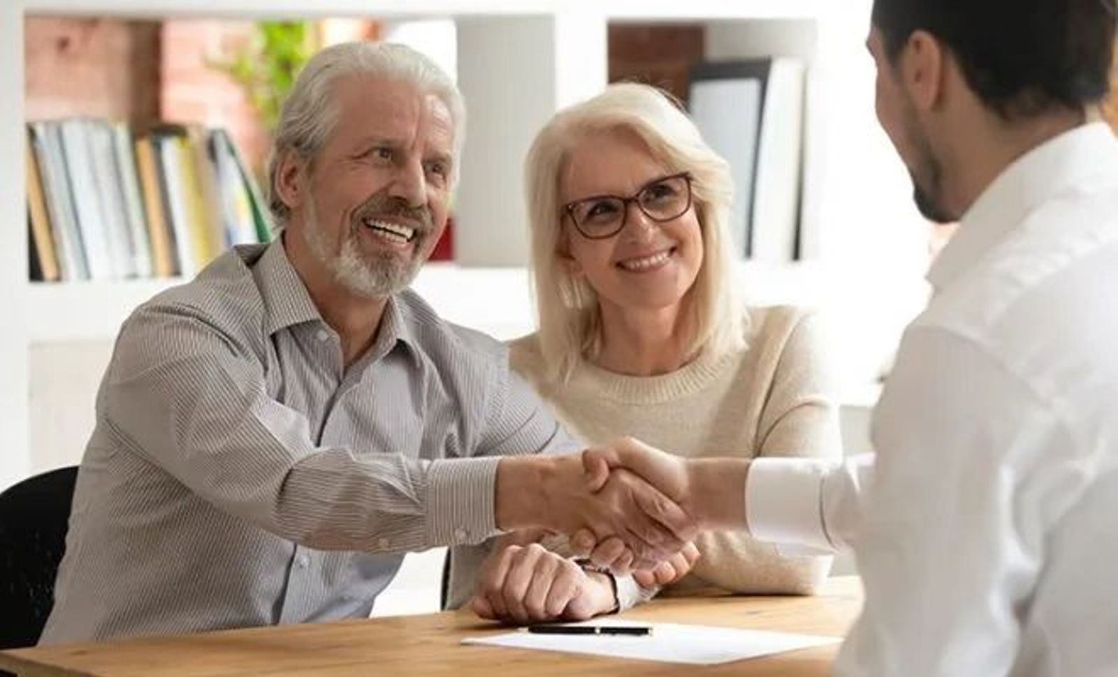 Retired Couple smiling shaking advisor hands