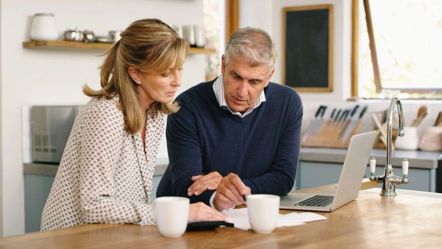 retired couple planning finances on kitchen table