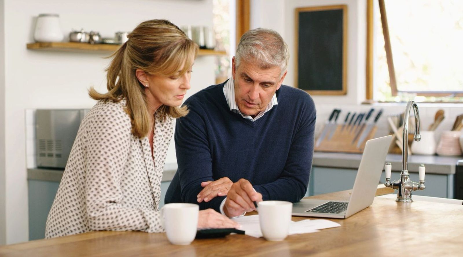 retired couple planning finances on kitchen table