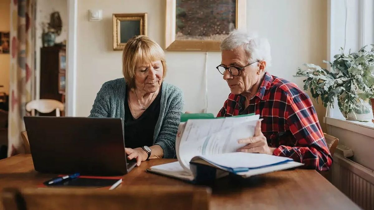 Couple reviewing Medicare enrollment paperwork at home