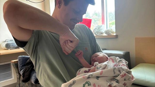 Father fist bumps newborn in the hospital