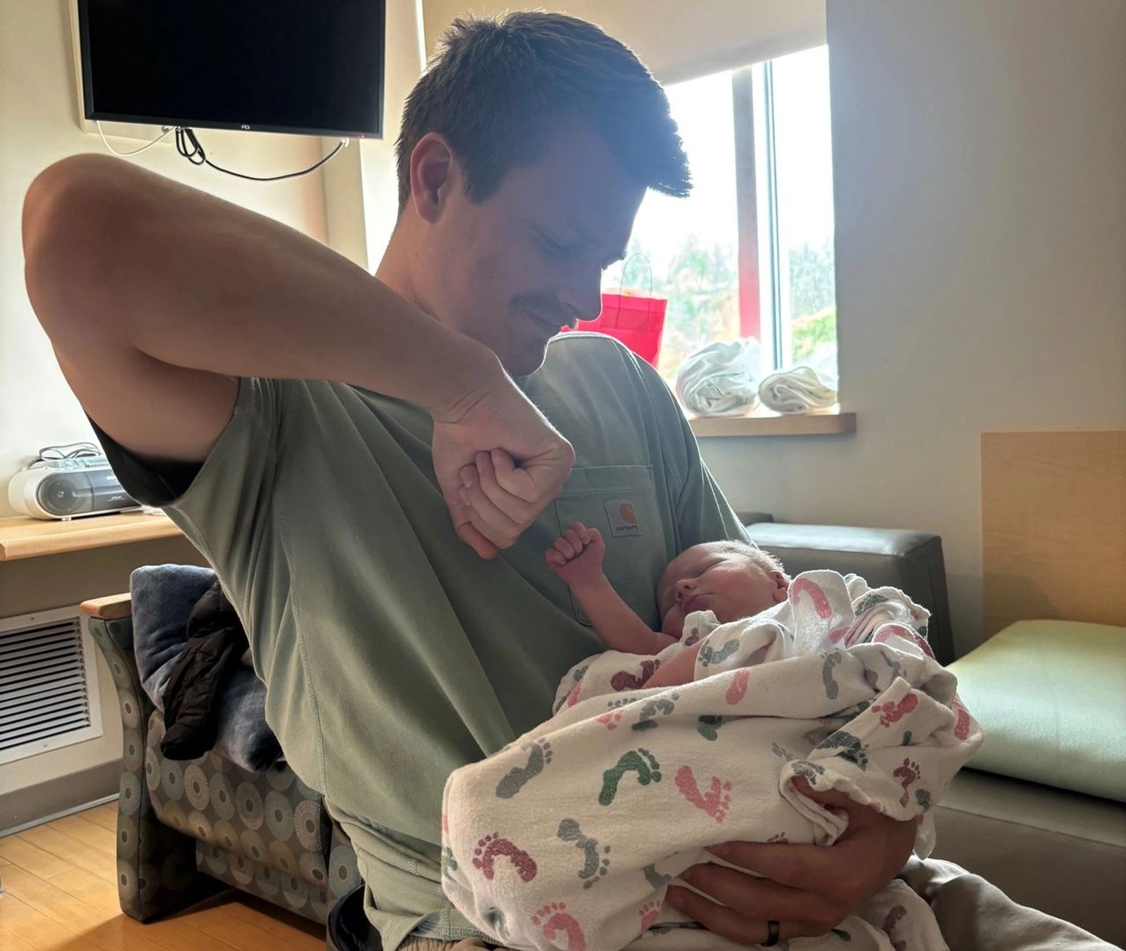 Father fist bumps newborn in the hospital