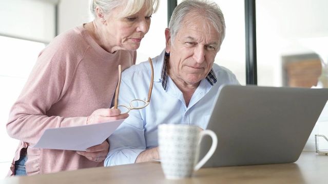Retired couple planning finances at kitchen table