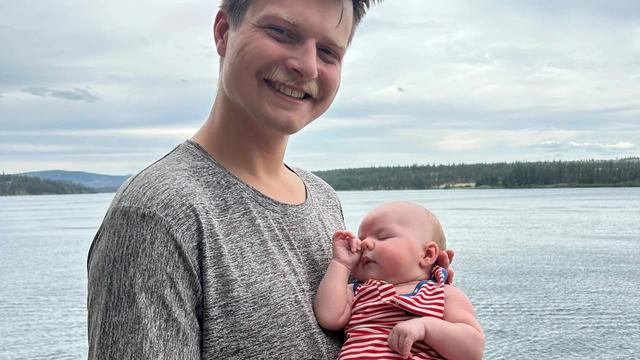 Man holding newborn at the lake