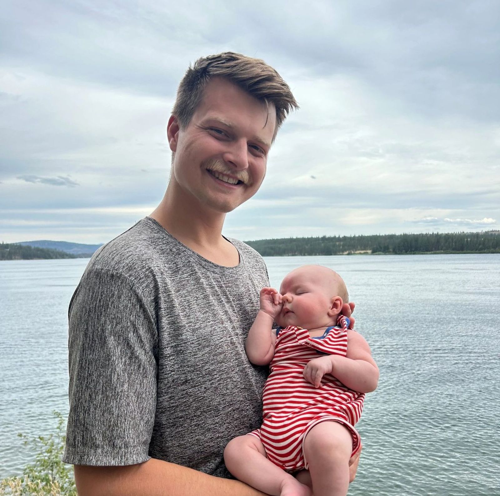 Man holding newborn at the lake