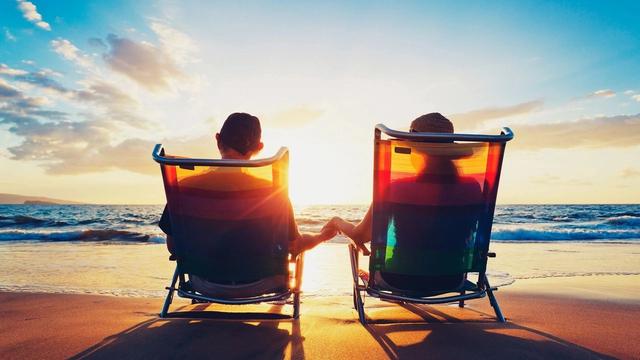 Couple sitting on a beach at sunset