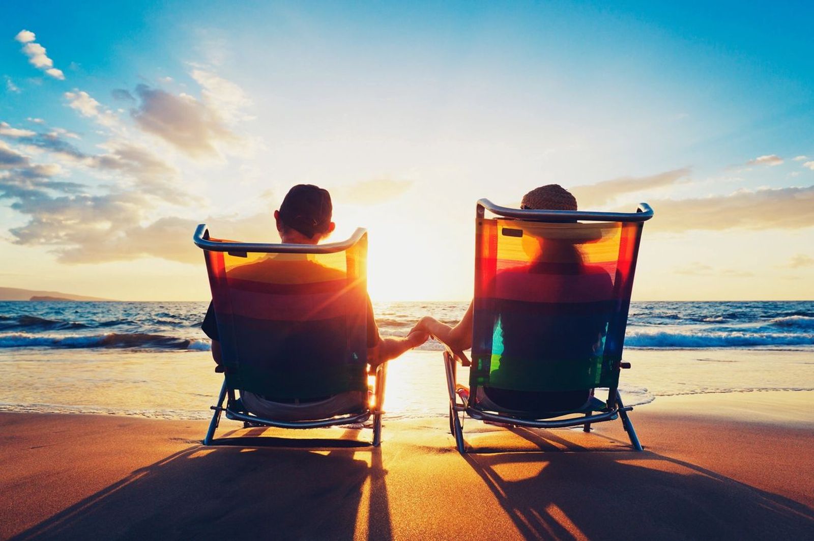 Couple sitting on a beach at sunset