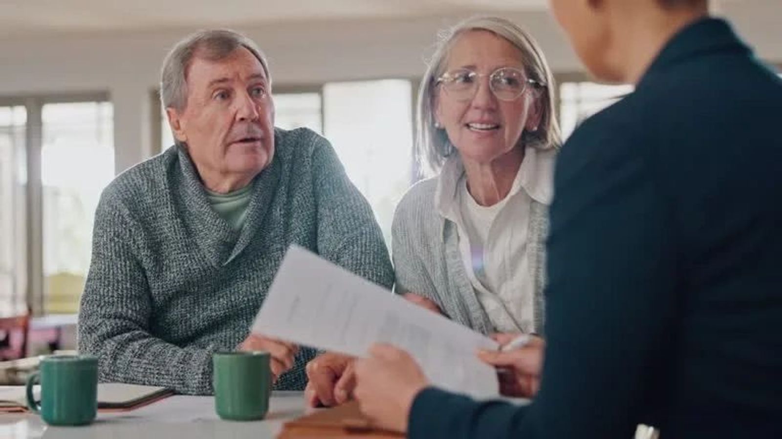 Retired couple meeting with a financial advisor to discuss retirement income, taxes, and safe withdrawal planning.