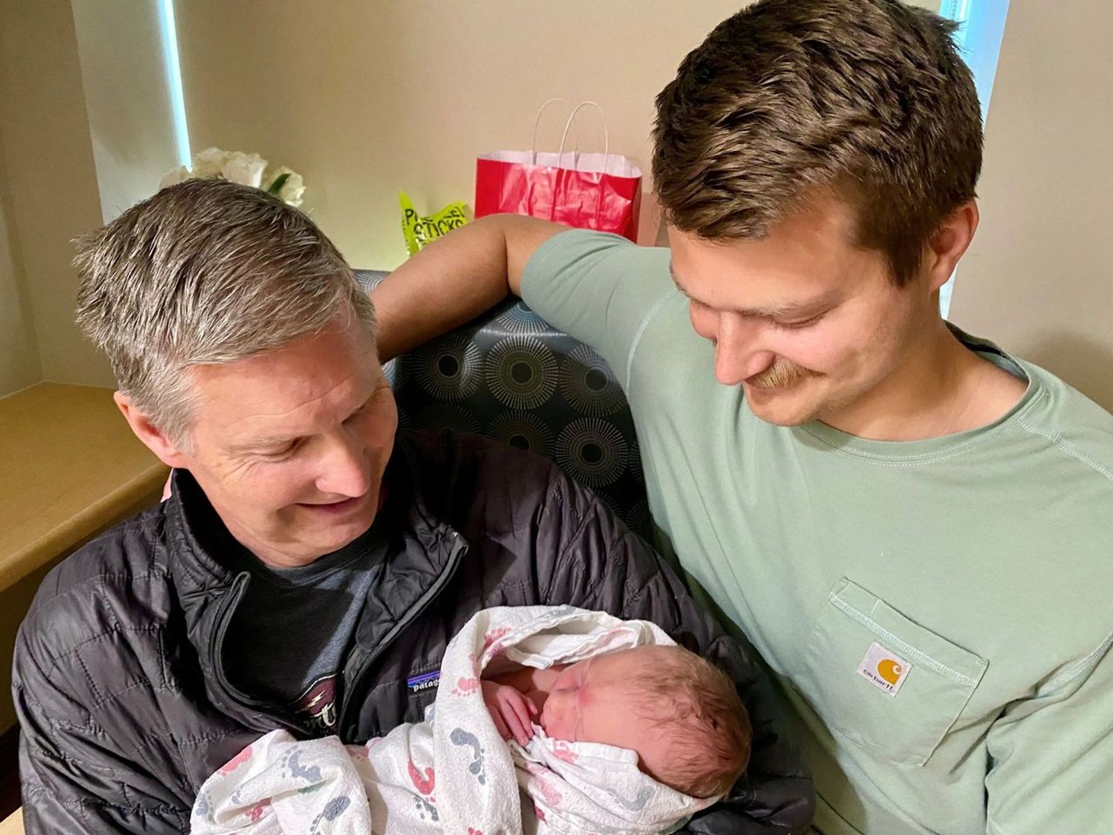 Grandfather, and father holding newborn