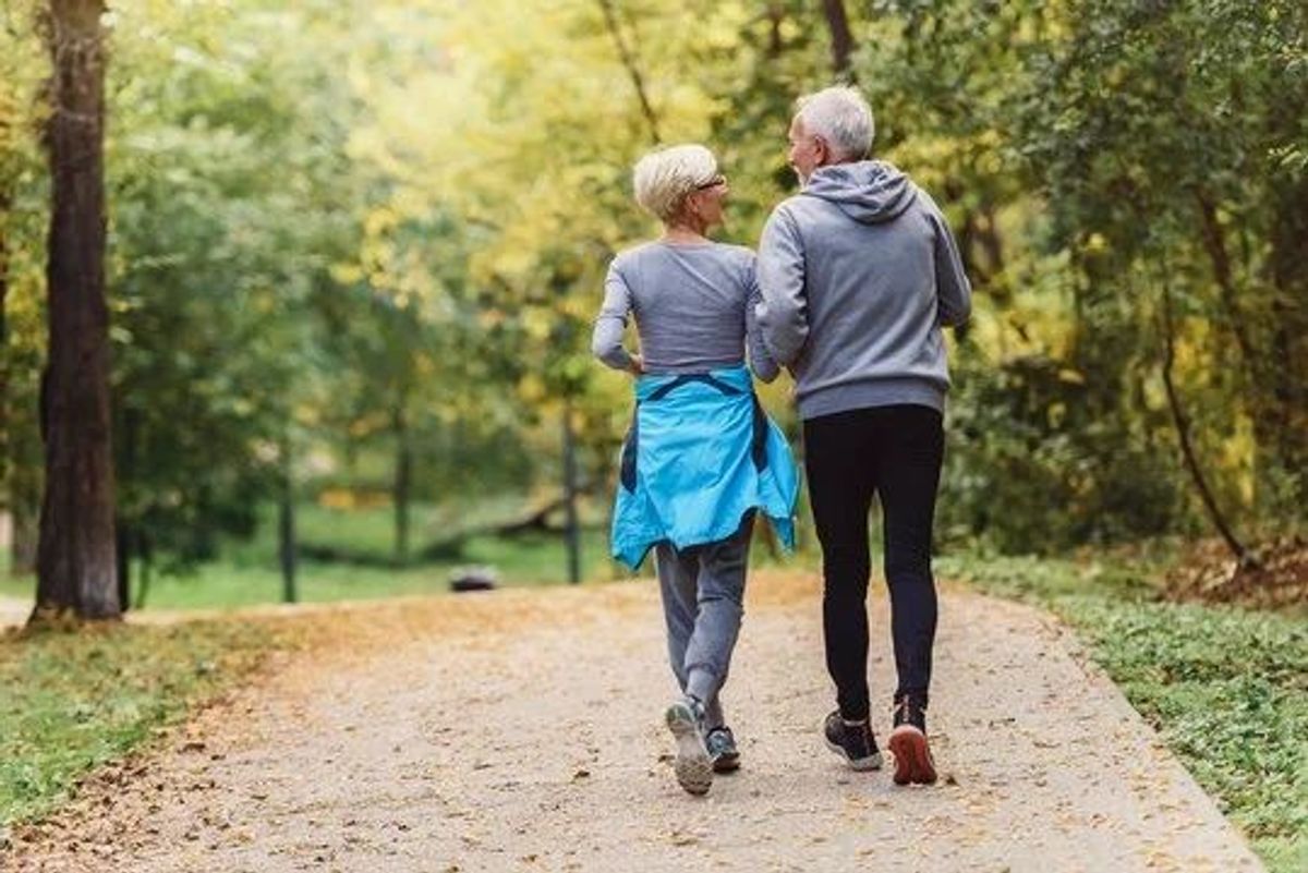 A retired couple walking through the woods, reflecting the freedom and lifestyle that thoughtful retirement planning can support.