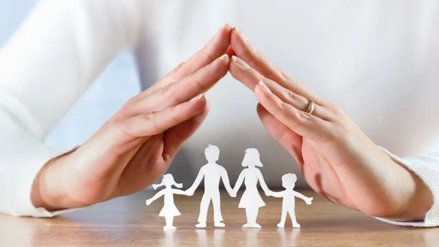 paper cutout family with hands forming roof over heads