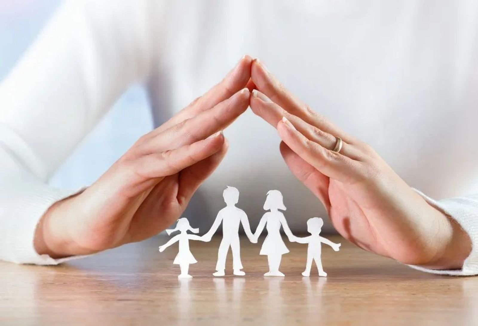 paper cutout family with hands forming roof over heads
