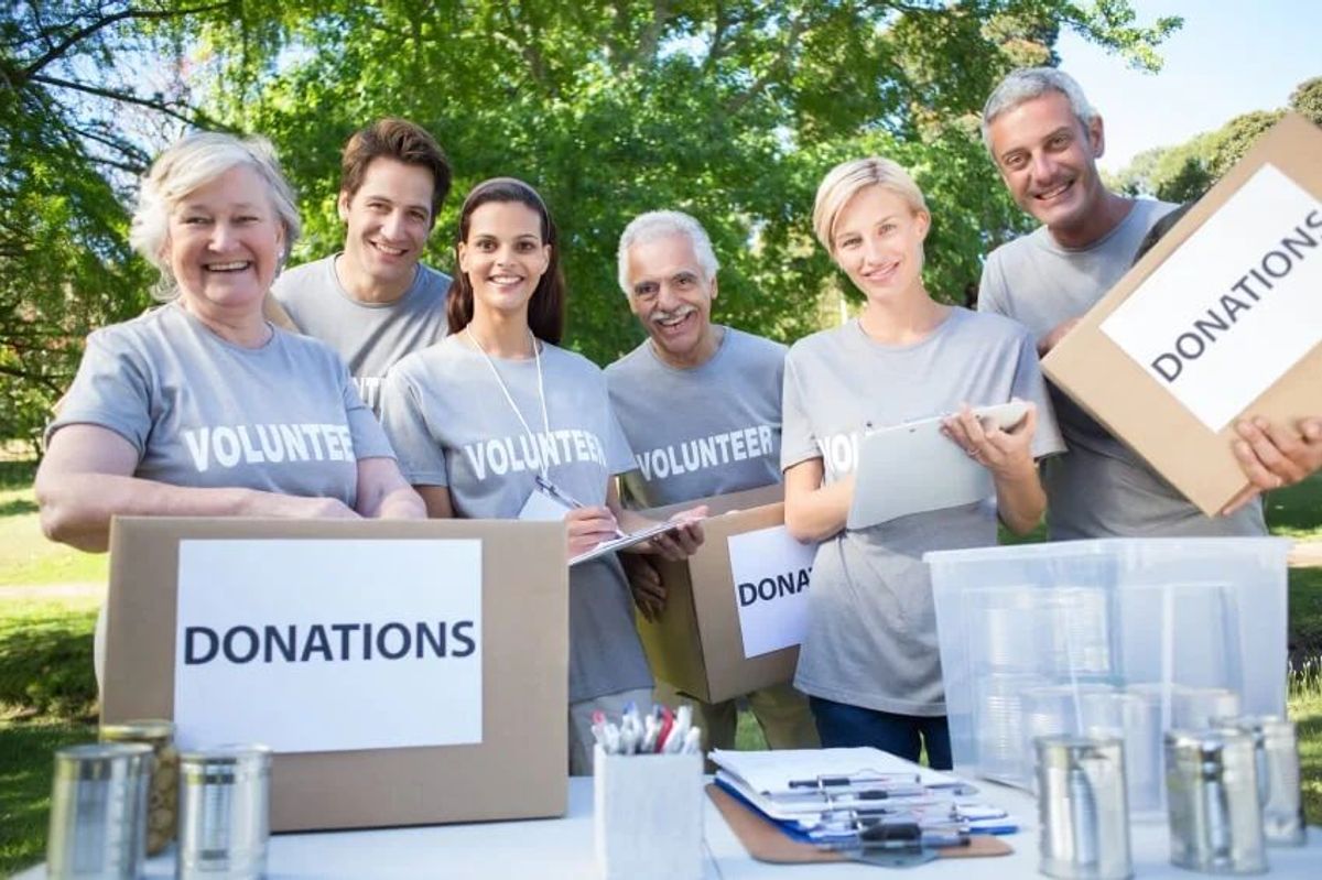 Volunteers holding boxes of donations in the park