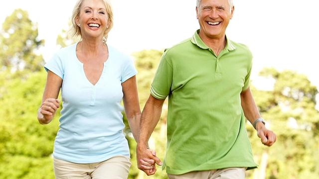 Retired couple  smiling while running