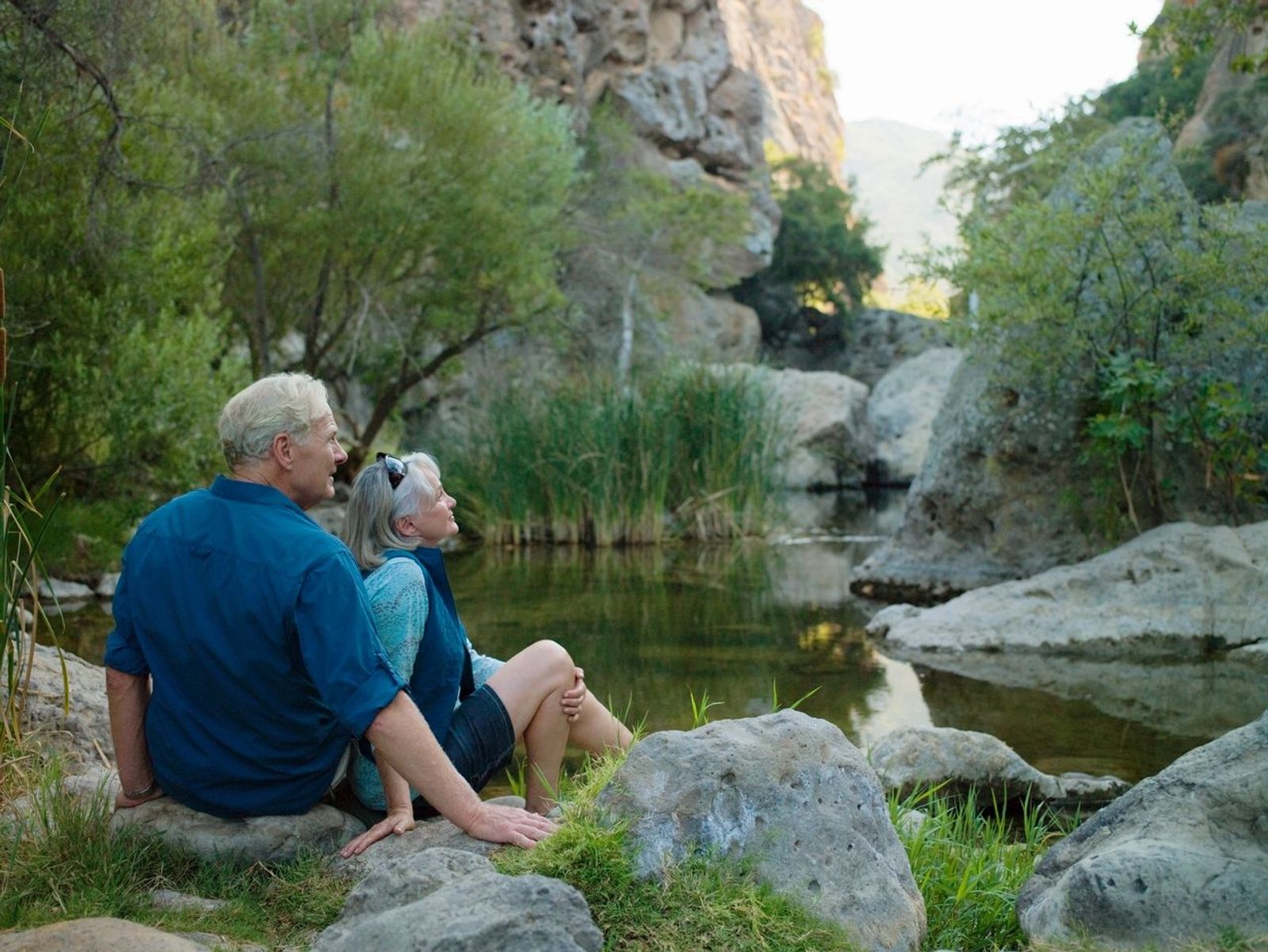 Old retirees sitting by a pond
