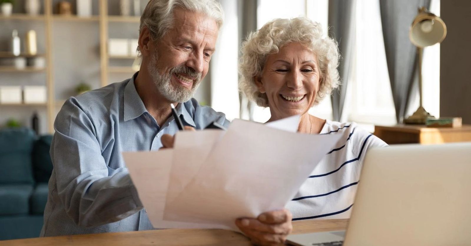 retired couple smiling working on paperwork