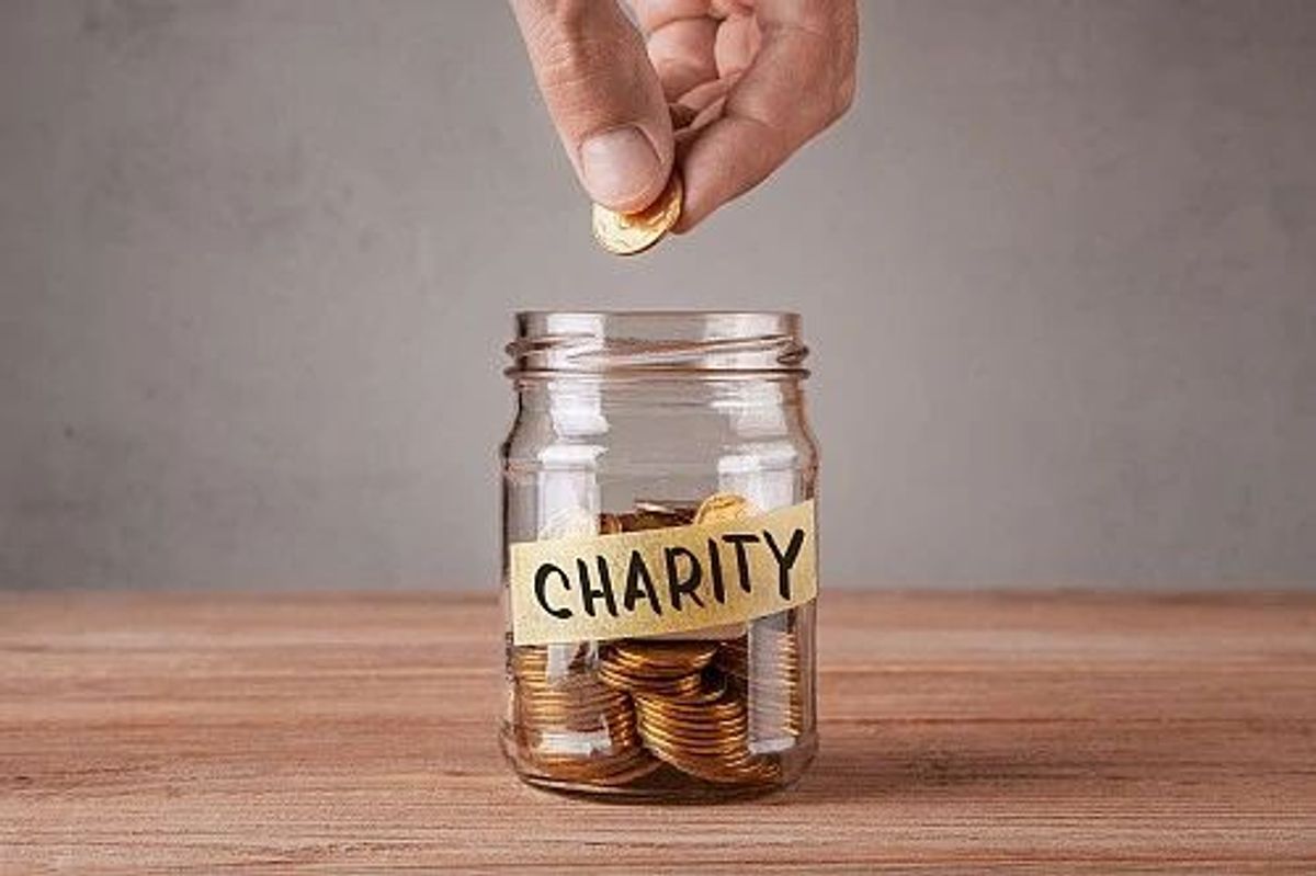 putting coin into charity jar