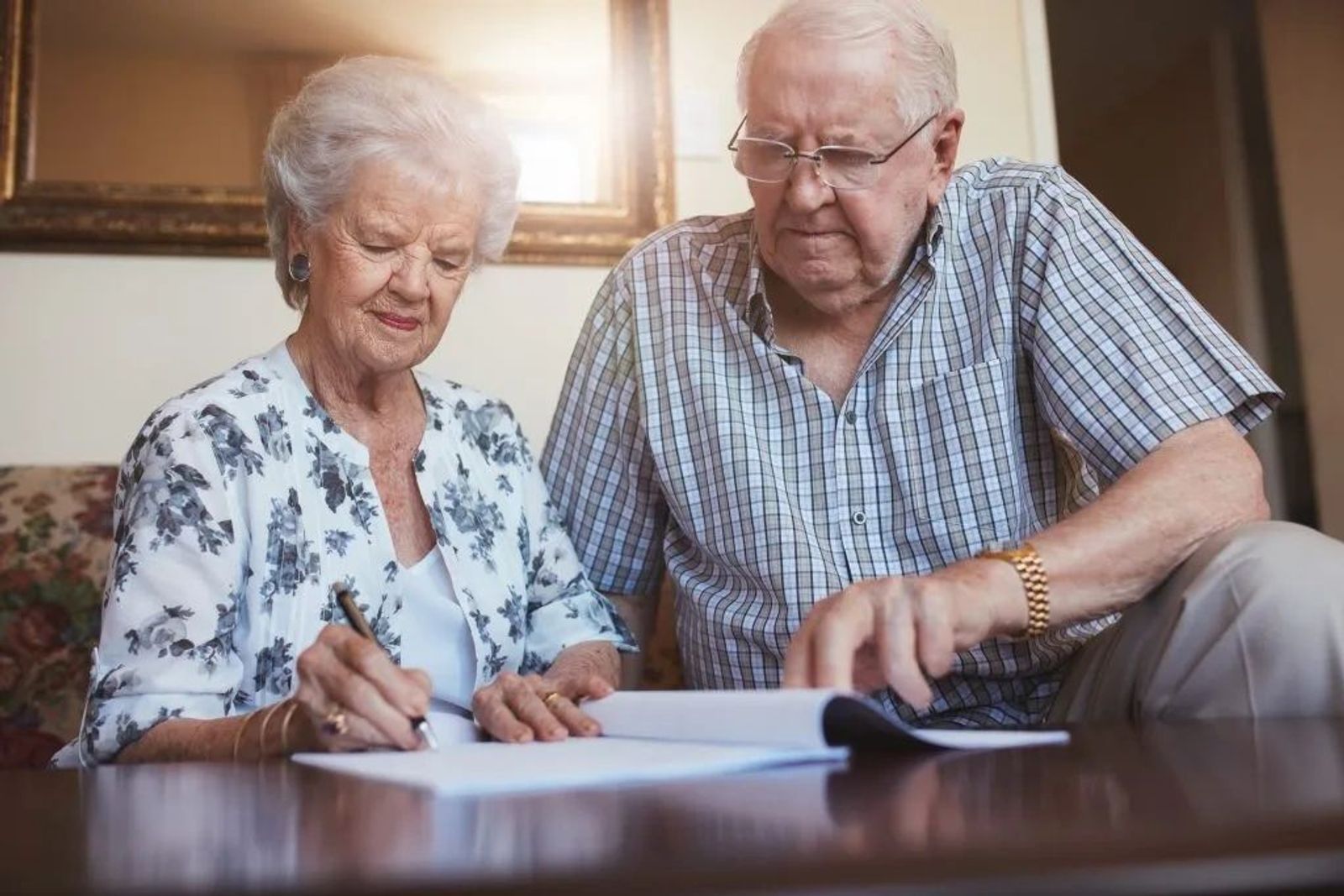 Retired couple signing will in living room