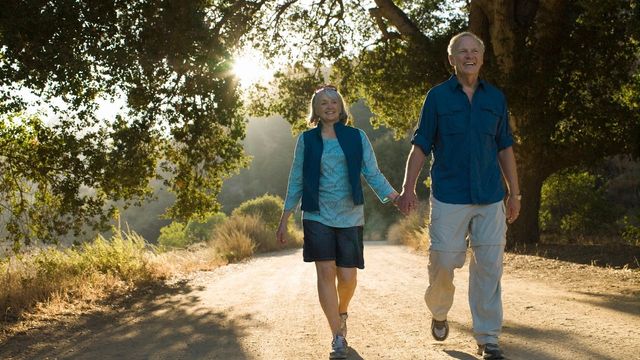 Retired couple holding hands on a walk