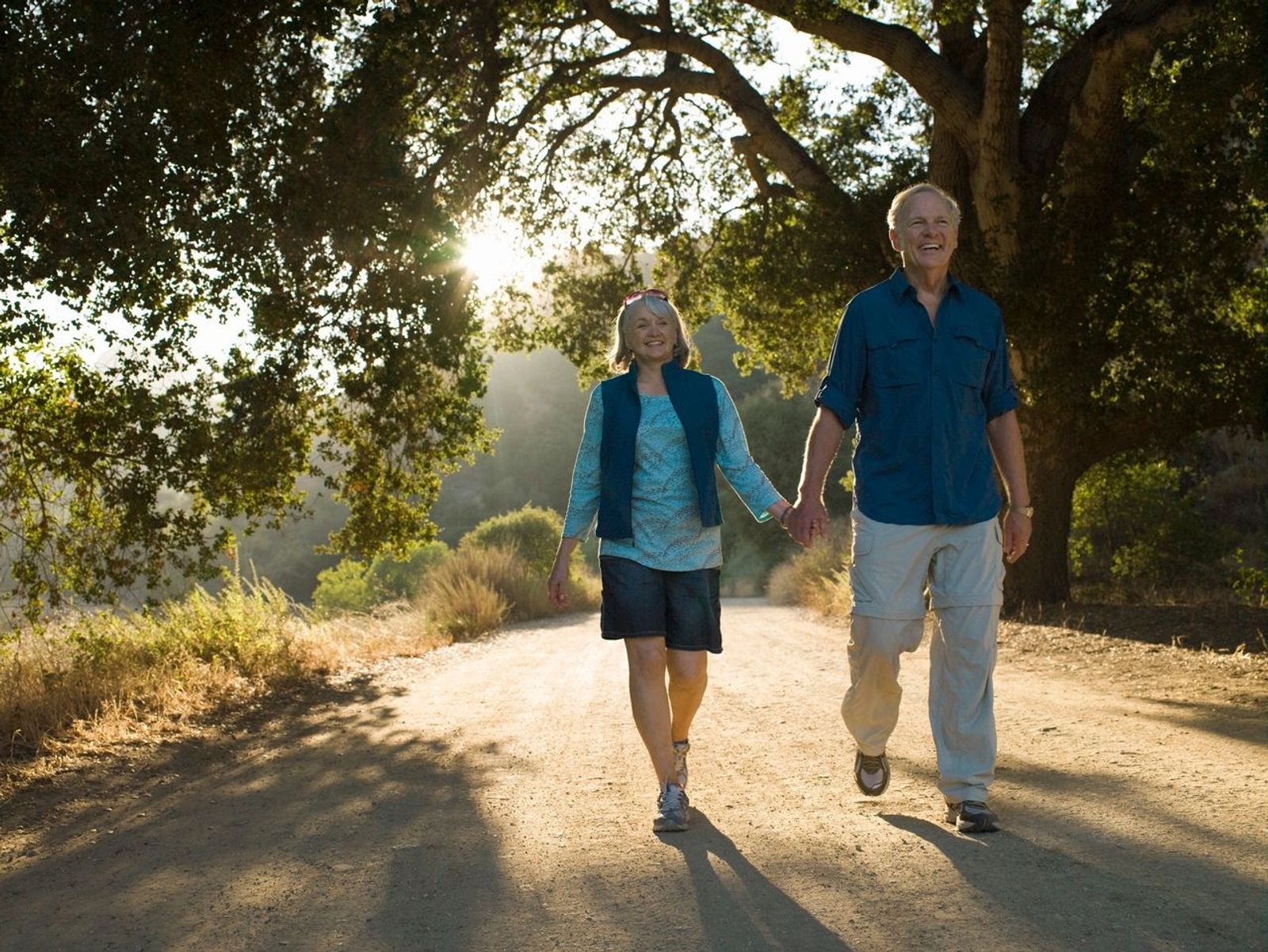 Retired couple holding hands on a walk