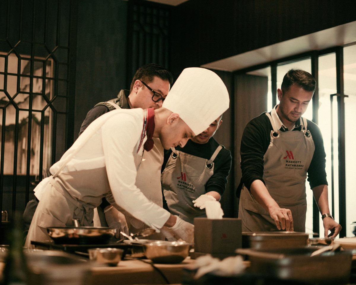 Team of chefs working together in a modern restaurant kitchen, preparing gourmet dishes with precision and skill.