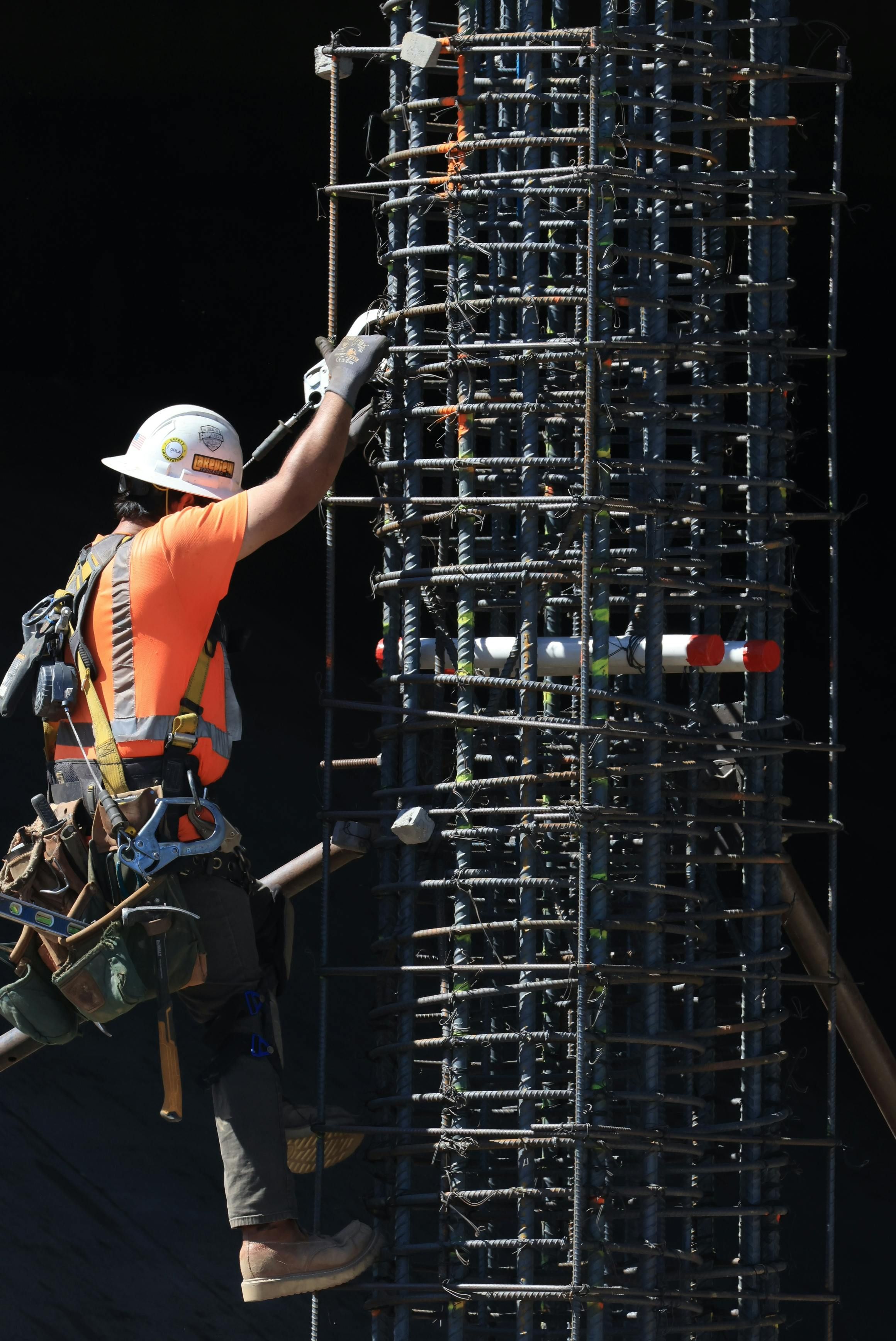 Worker reviewing site hazards and safety signage for compliance.