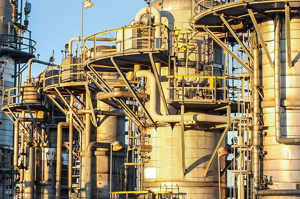 Chemical plant with containment systems and safety signage.