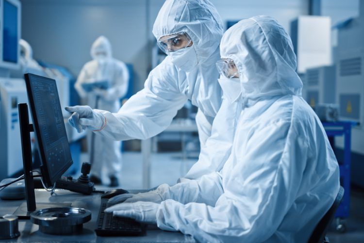 EHS specialist testing air quality in a manufacturing cleanroom.