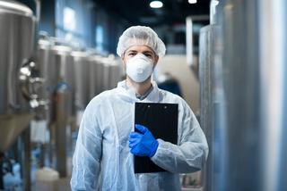 Industrial hygienist measuring air quality in a manufacturing facility.