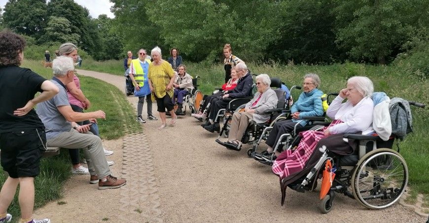 Bewoners en vrijwilligers van Oranjehof wandelen samen met wijkbewoners naar de Corisberg voor koffie en vlaai, bevordert gezelligheid en sociale verbinding