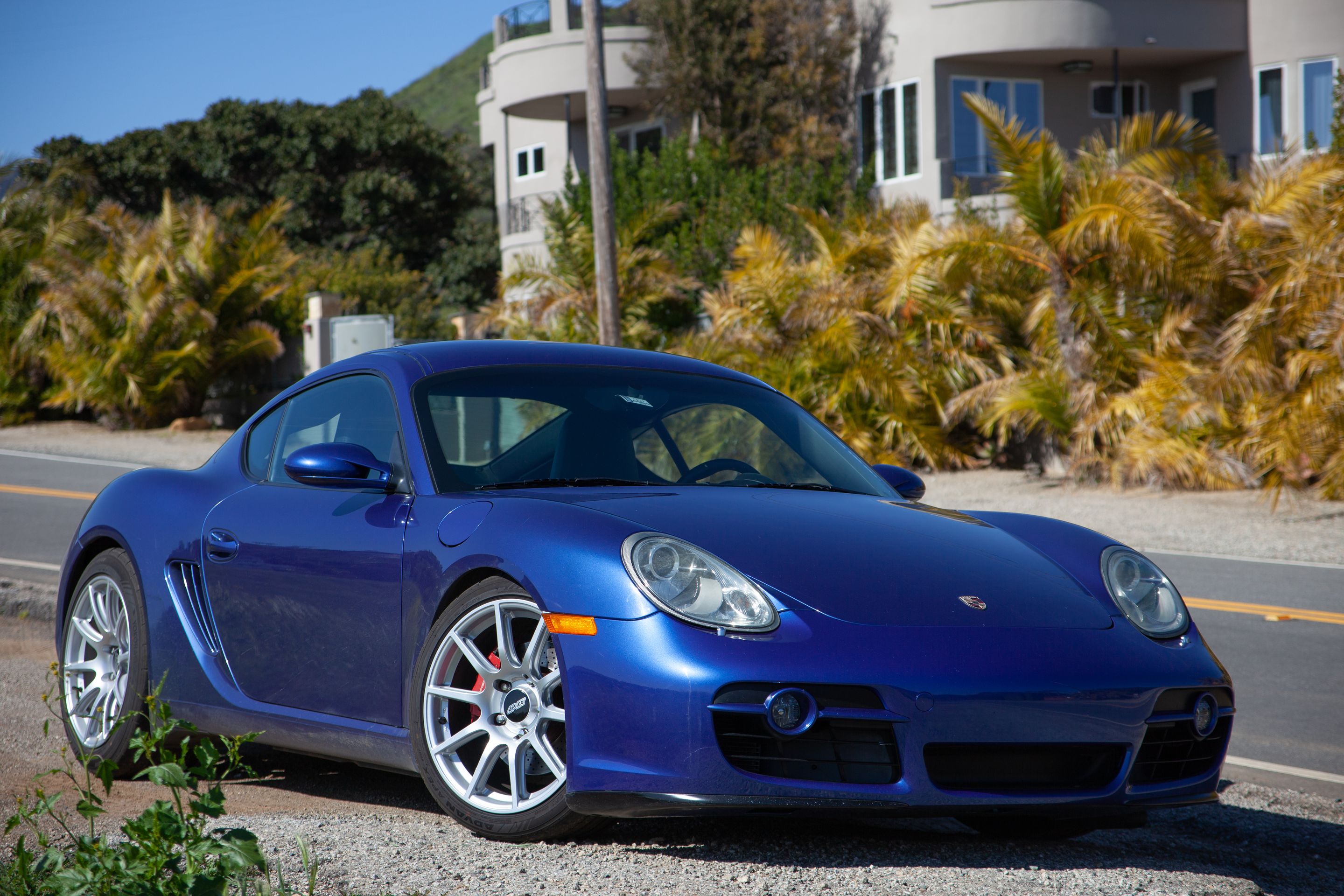 Blue Porsche 987 Cayman S with 18" SM-10 Apex wheels in Race Silver