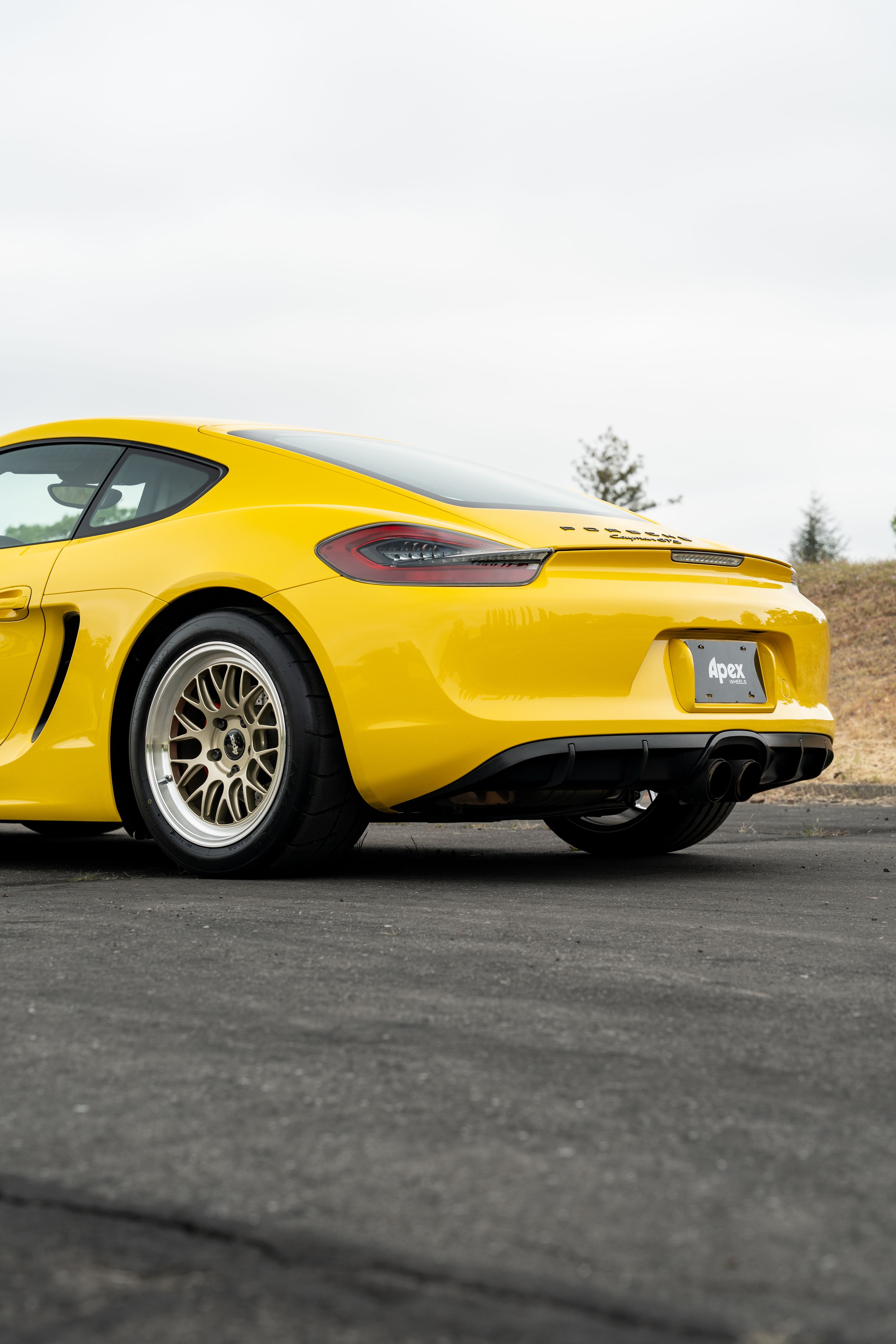 Yellow Porsche 981 Cayman GTS with 18" ML-10RT Apex wheels in Machined Lip Gloss Motorsport Gold