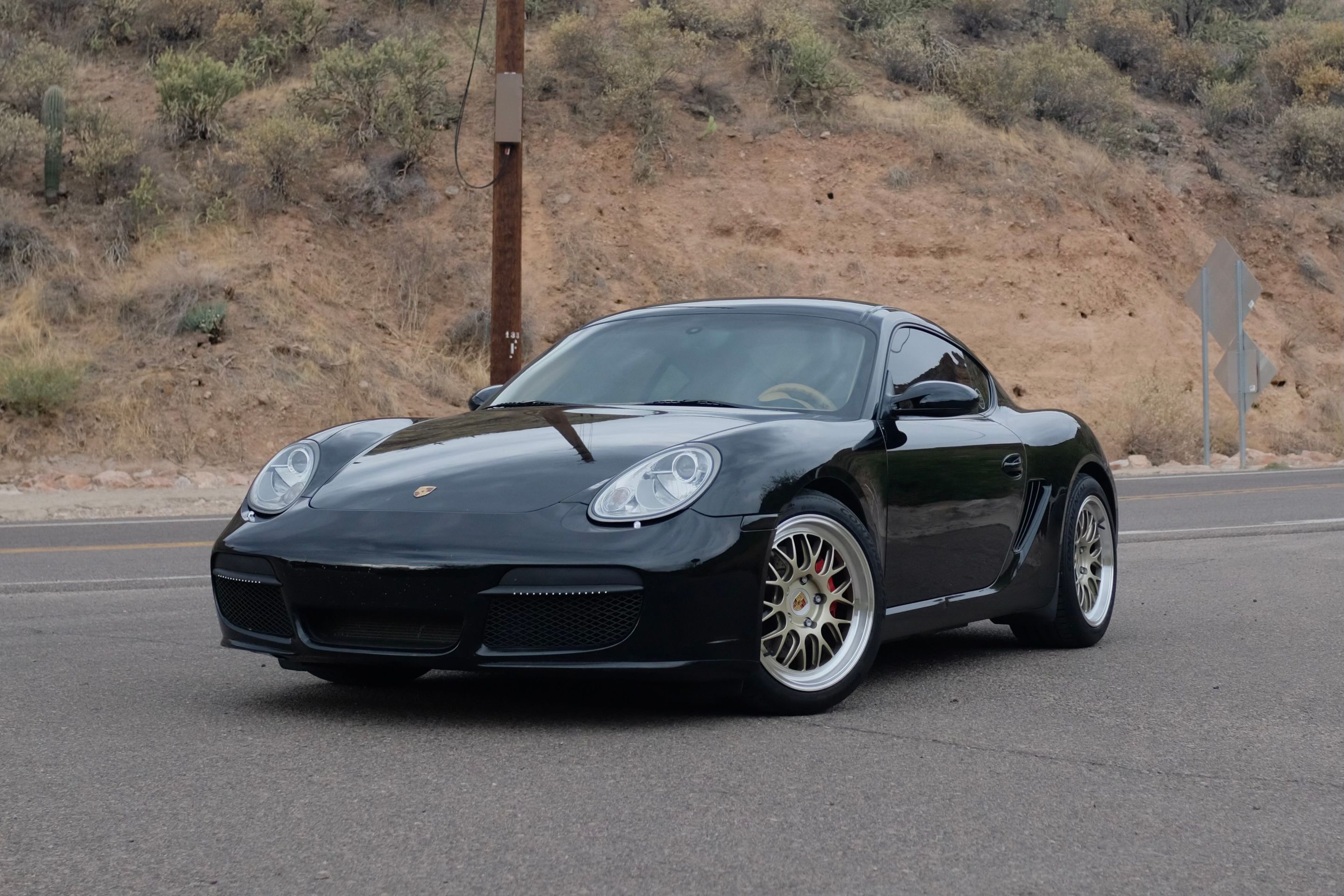 Black Porsche 987 Cayman S with 18" ML-10RT Apex wheels in Machined Lip Gloss Motorsport Gold