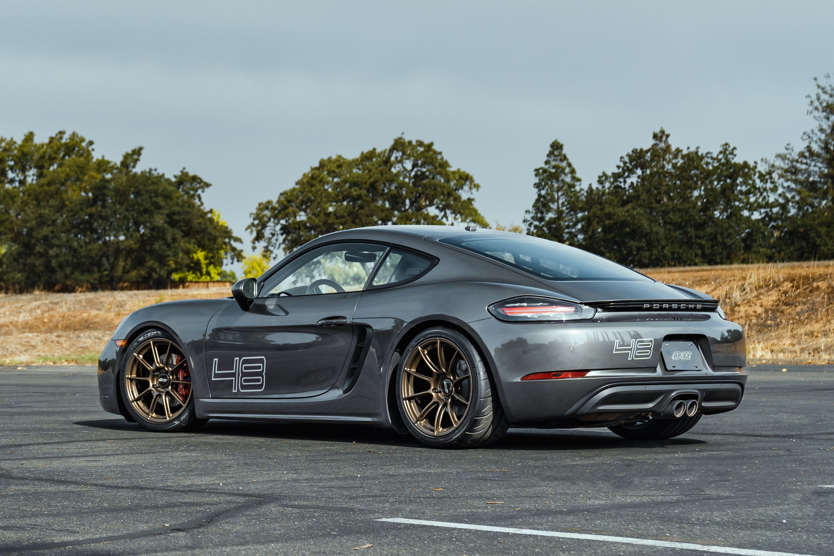 Grey Porsche 718 Cayman S with 19" SM-10RS Apex wheels in Satin Bronze