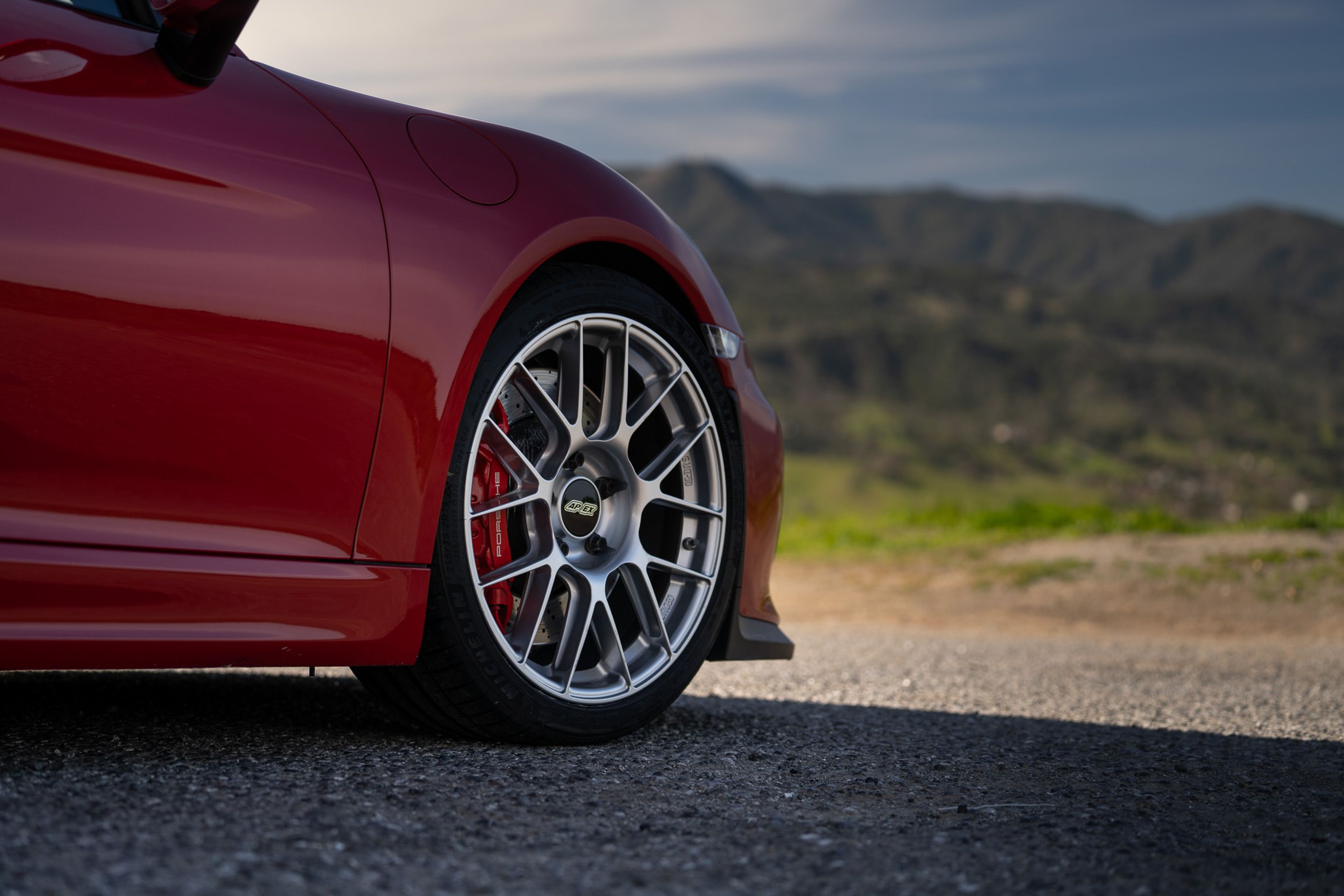 Red Porsche 981 Cayman GT4 with 19" EC-7RS Apex wheels in Race Silver