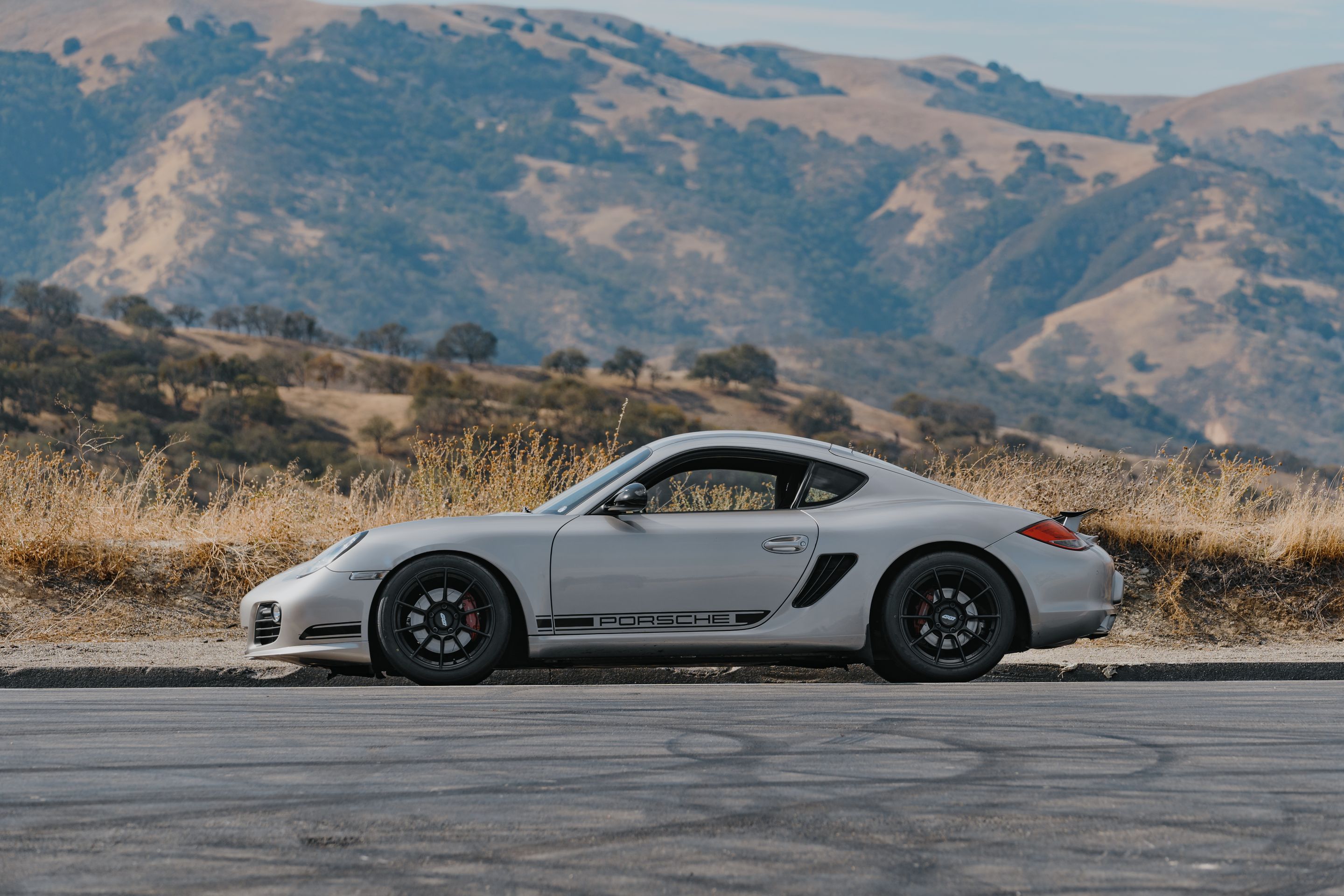 Silver Porsche 987 Cayman R with 18" SM-10RS Apex wheels in Satin Black