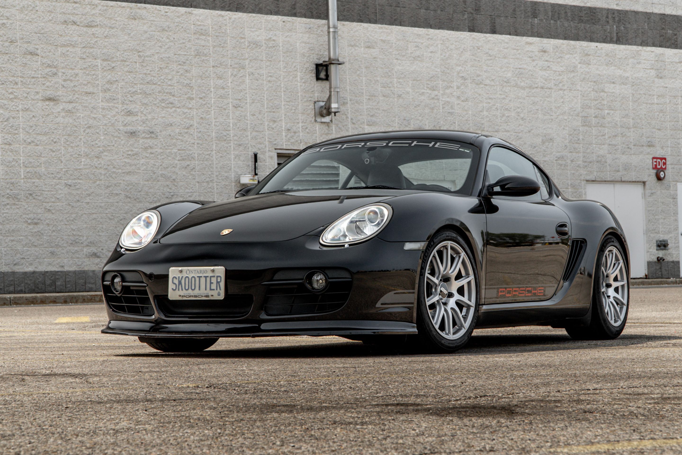 Black Porsche 987 Cayman Base with 18" SM-10 Apex wheels in Race Silver