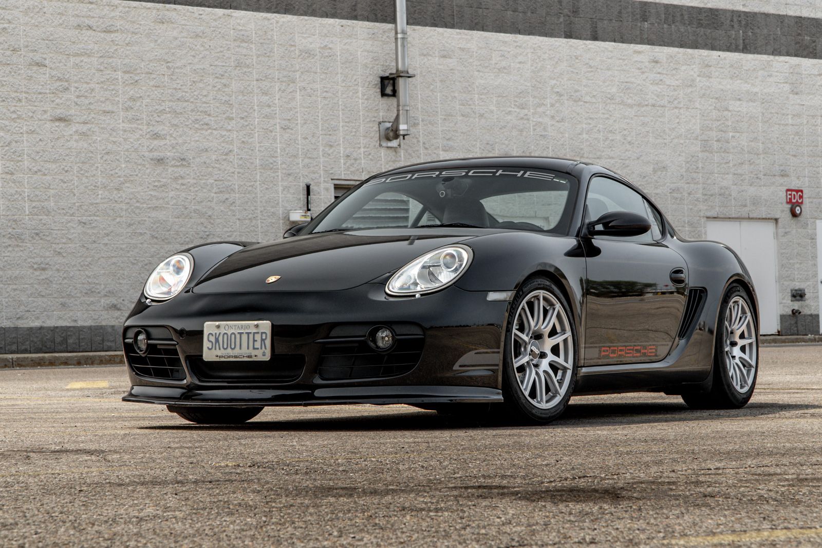 Black Porsche 987 Cayman Base with 18" SM-10 Apex wheels in Race Silver