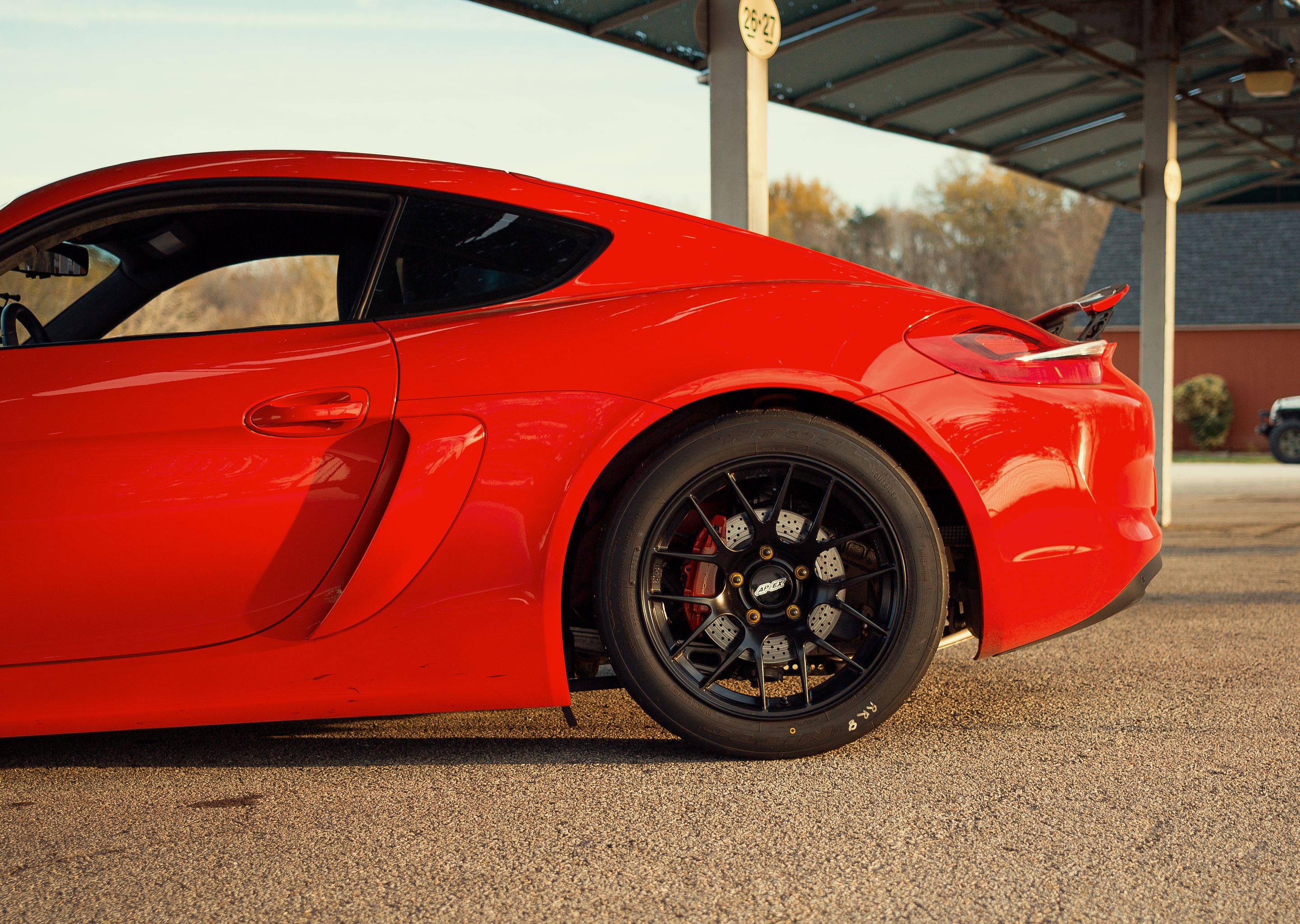Red Porsche 981 Cayman S with 18" EC-7R Apex wheels in Satin Black