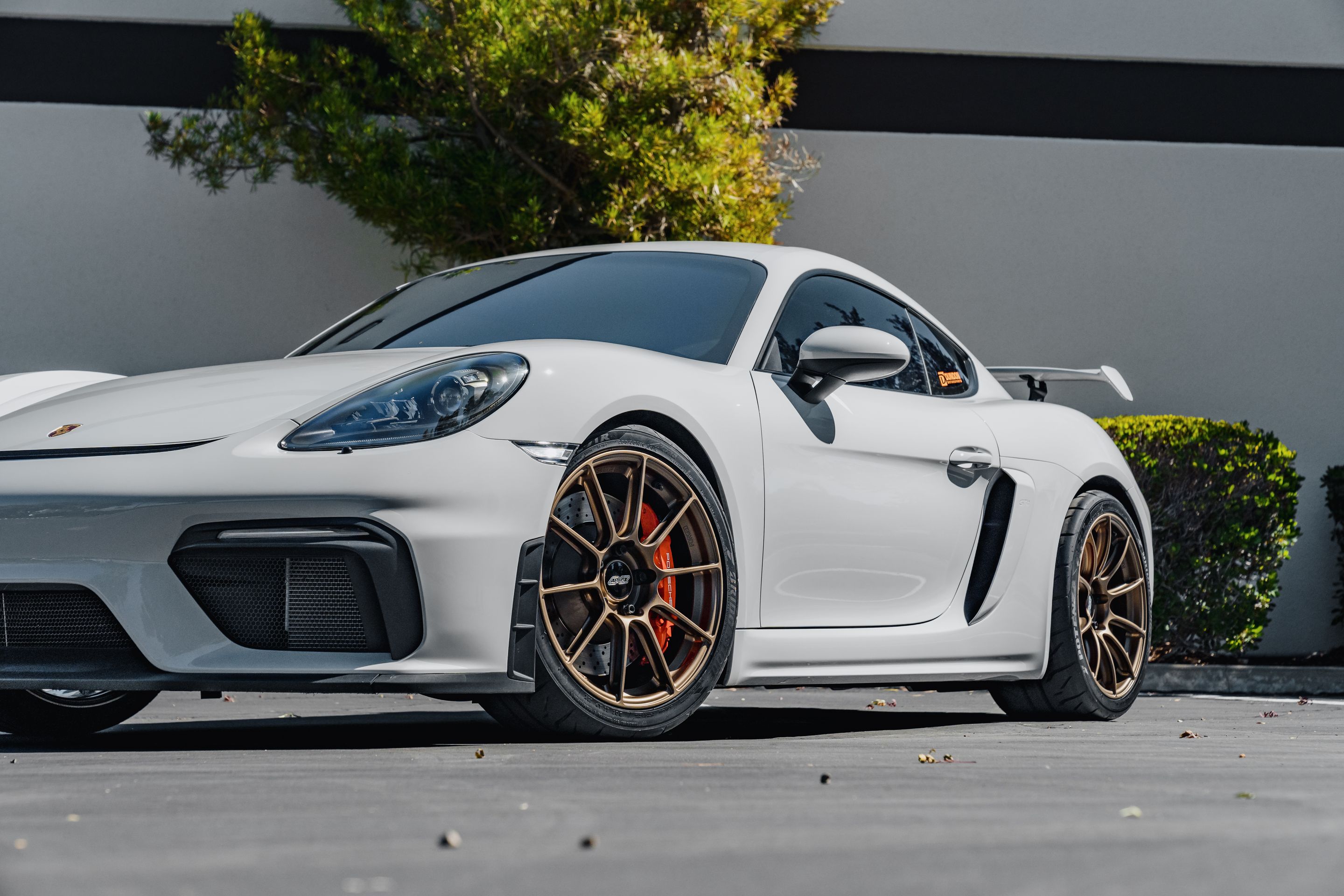 Grey Porsche 718 Cayman GT4 with 19" SM-10RS Apex wheels in Satin Bronze